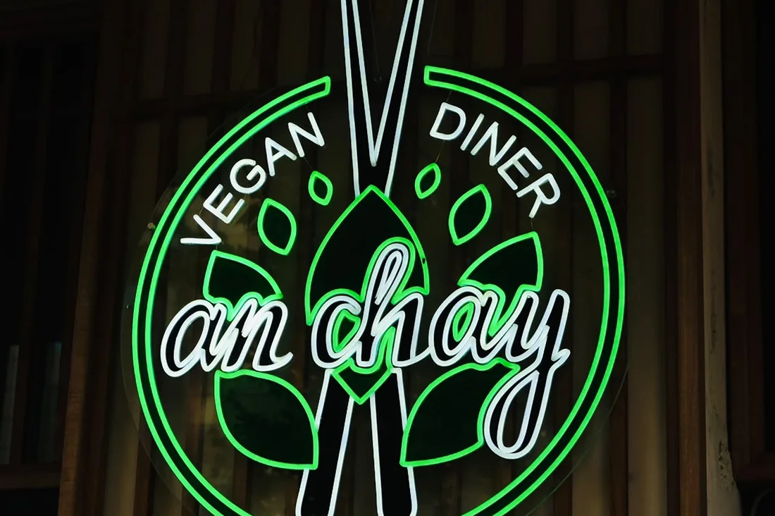 Leuchtschild „an chay – Vegan Diner“ über dem Eingang des Restaurants